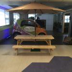 Picnic Table and Patio Umbrella in front of Smart Car